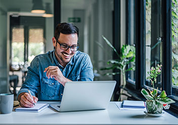 Man reading FAQs on his laptop.